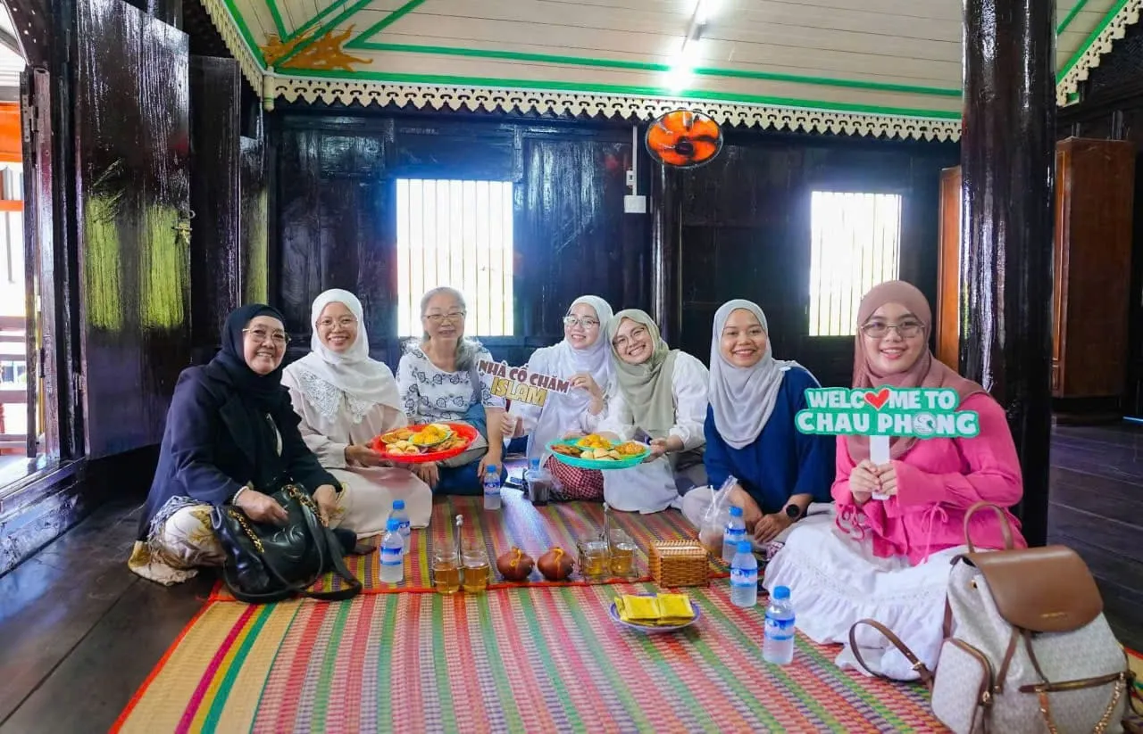 Sarah Jenkins từ Sydney, Australia thưởng thức bánh Chăm truyền thống tại ngôi nhà cổ Chăm Islam, Châu Giang, An Giang — Kim Quang Bakery
